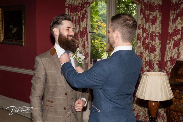 Two people share an emotional moment in a room with red wallpaper.