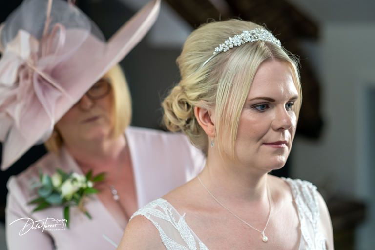 Wedding party members in soft pink attire prepare for the ceremony.