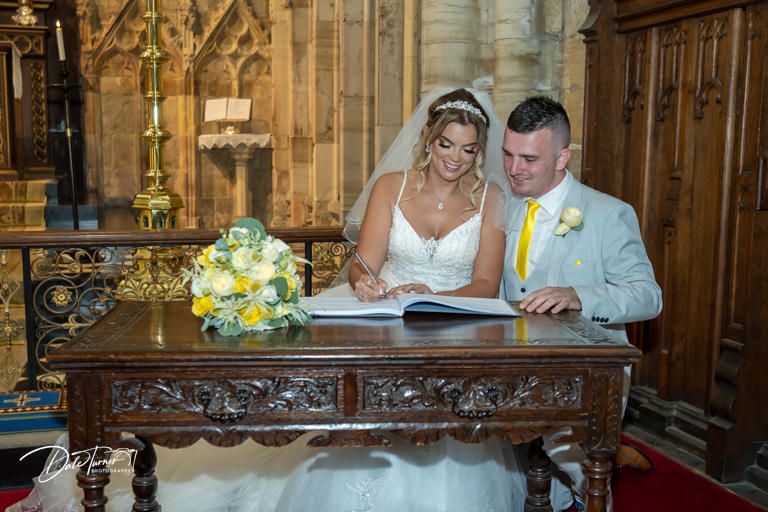 Elegant wedding ceremony taking place at carved wooden altar in historic cathedral.
