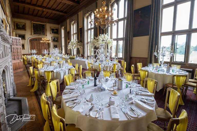 Elegant wedding reception room with chandelier and formal table settings.