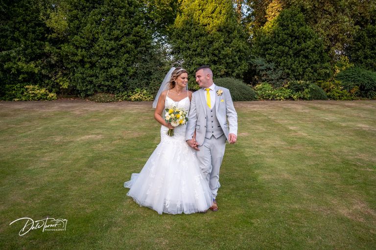 Outdoor wedding photography session in a natural garden setting with grey and white attire.