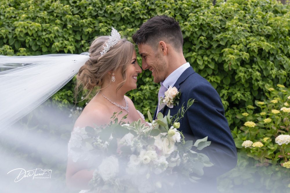 Lush garden setting with flowering bushes and greenery creating a romantic backdrop.