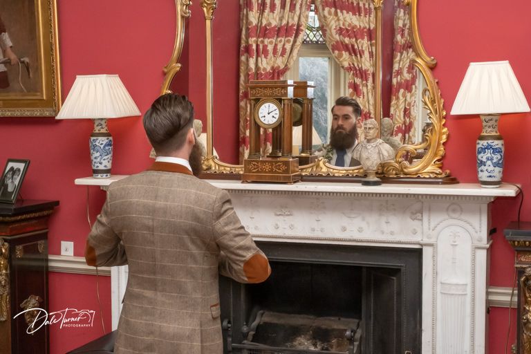 Luxurious room with red walls featuring ornate fireplace and classic decor.