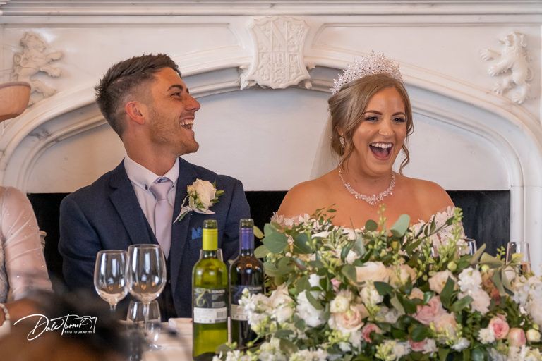 Wedding reception celebration with elegant table settings and floral arrangements.