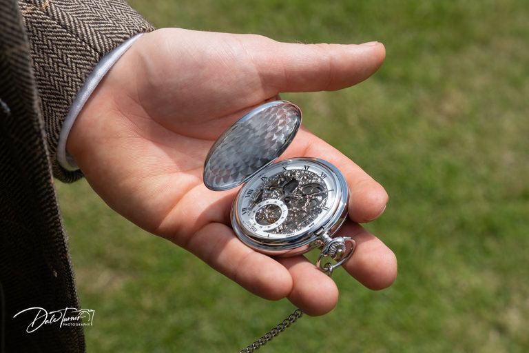 Close-up shot of an antique pocket watch being held in someone's hand.