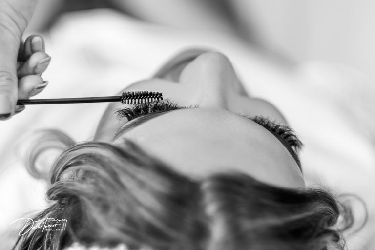 Close-up black and white detail of wedding day preparation and styling.
