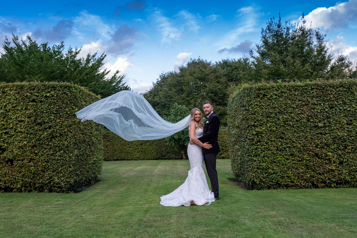 Wedding photography sequence with flowing veil against green hedges and blue sky.