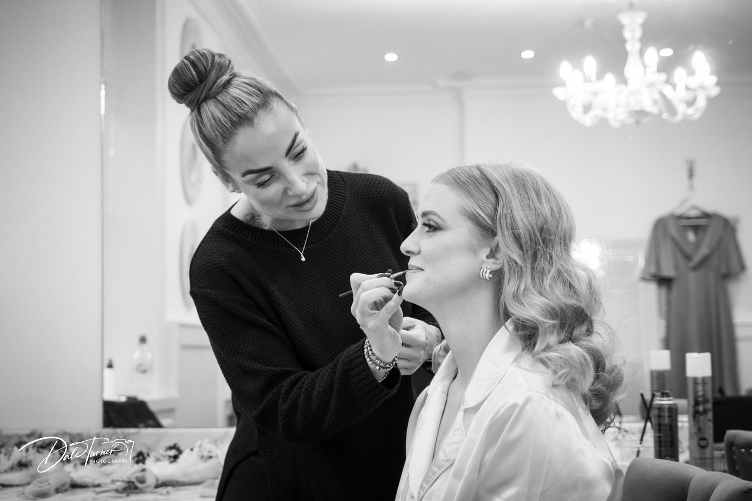 Professional makeup application and styling preparations before a wedding ceremony.