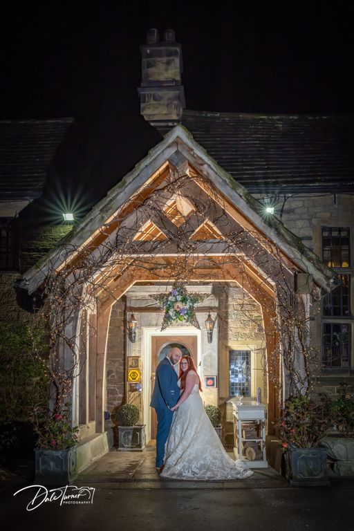 Rustic wooden church entrance lit up at night for an intimate wedding ceremony.