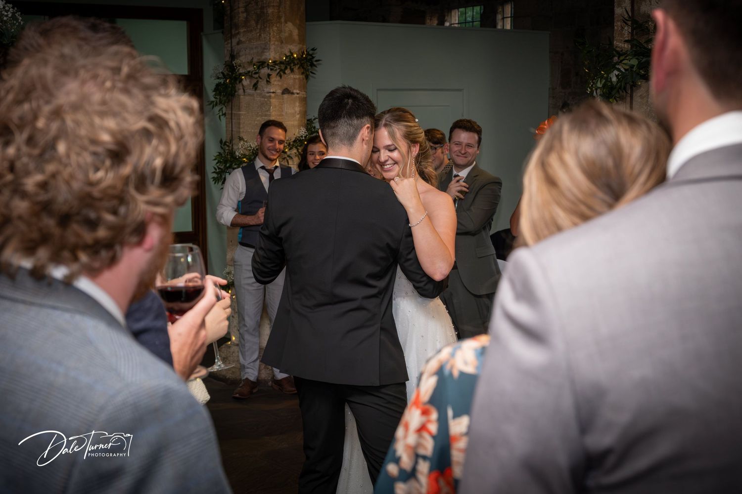 A reception celebration captured in motion with guests watching the festivities.