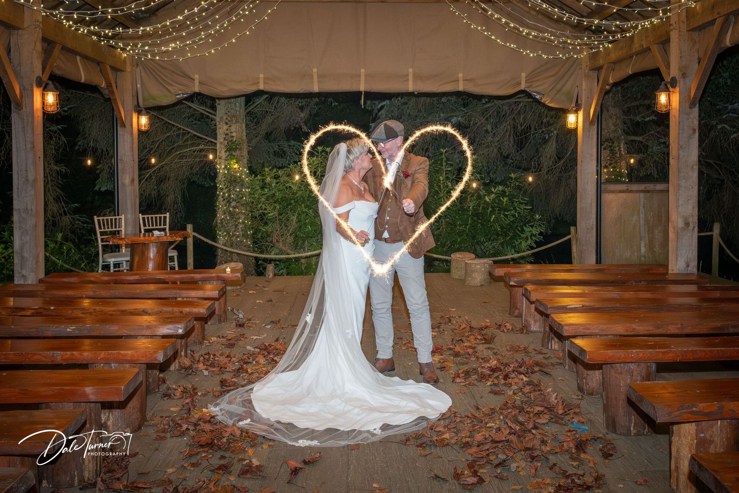 Wedding venue decorated with string lights and illuminated LOVE sign creating romantic ambiance.