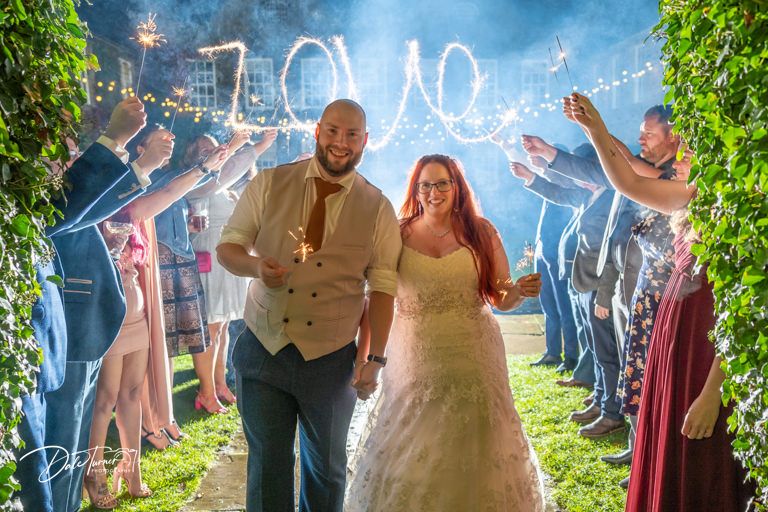Wedding celebration on dance floor with blue lighting and festive atmosphere.