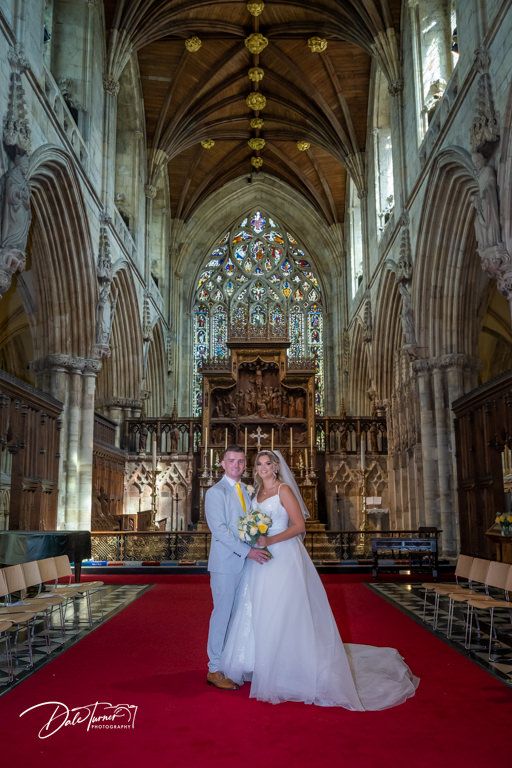 Gothic church interior with vaulted ceilings, stained glass windows and red carpet aisle.