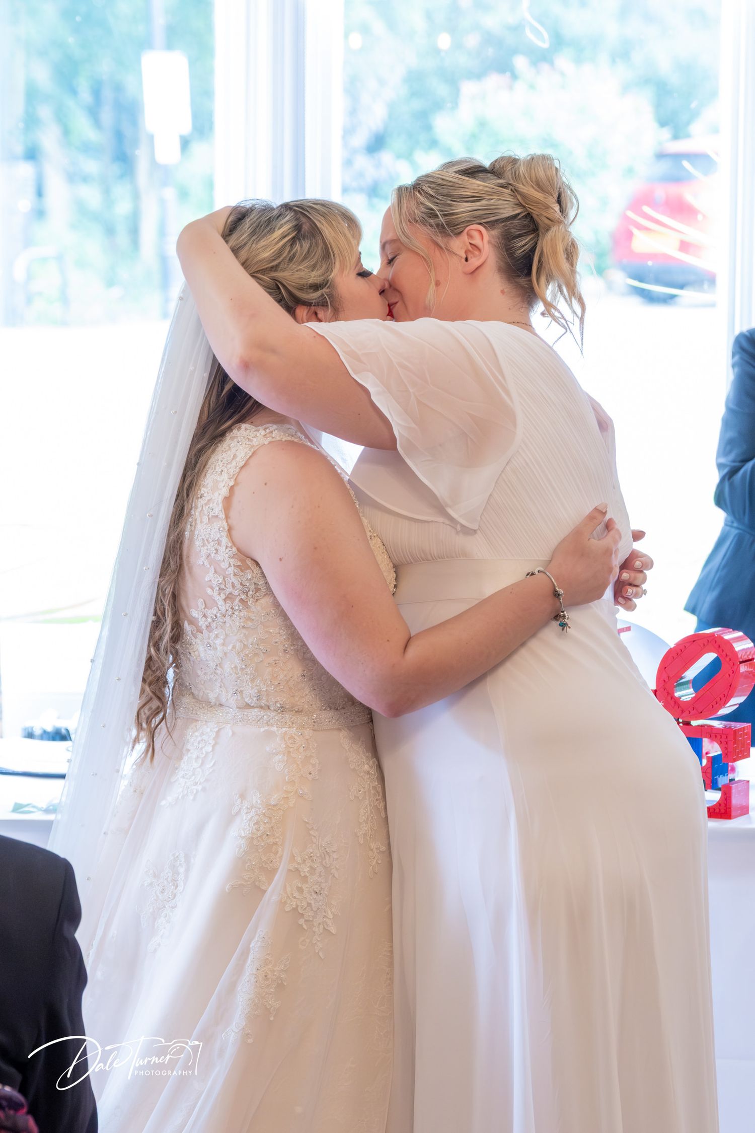 Intimate wedding ceremony moment captured indoors with decorative LOVE sign visible.