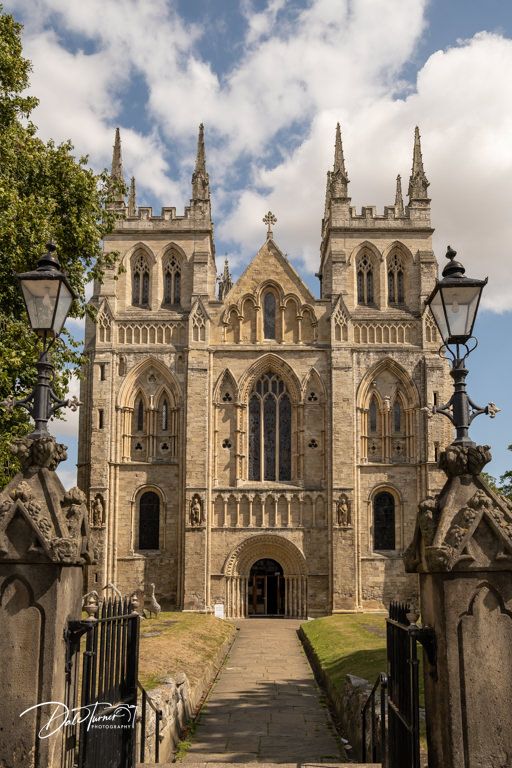 Stone cathedral entrance with Gothic architecture and steps leading to ornate doorway.