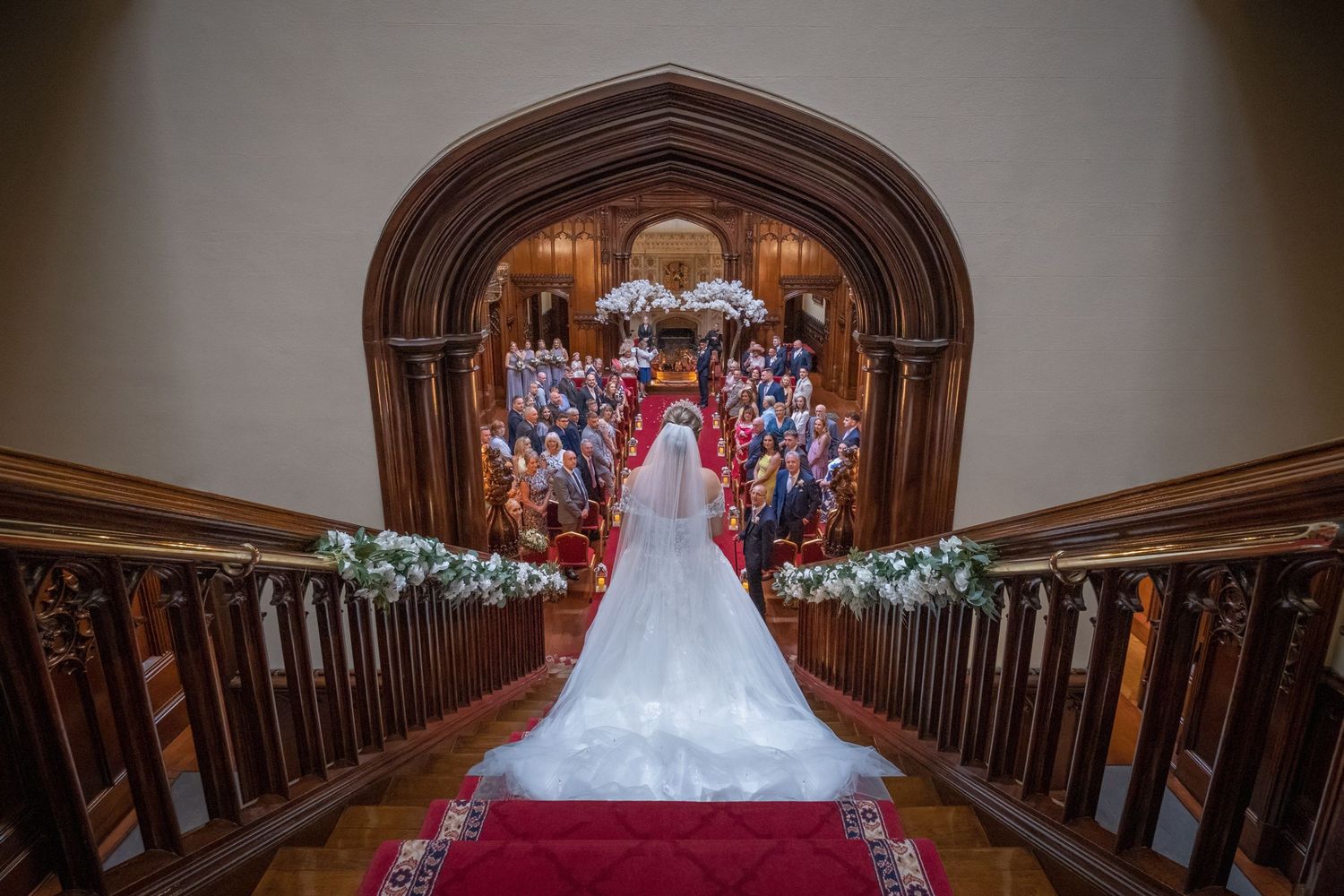Interior view of a grand church aisle with wooden pews and ornate architectural details.