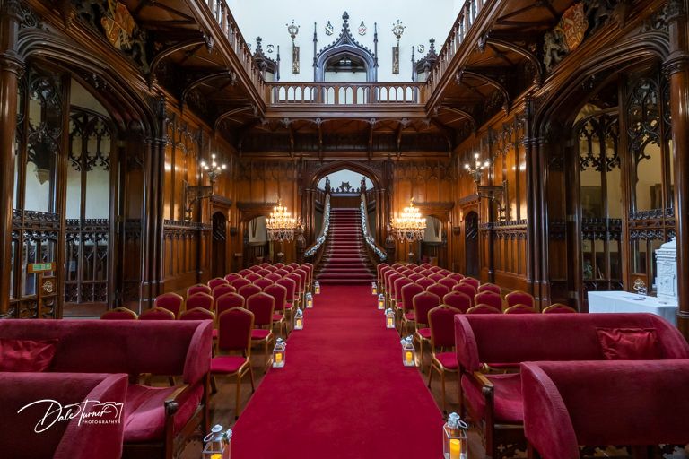Gothic-style church interior with red carpet aisle and wooden pews.