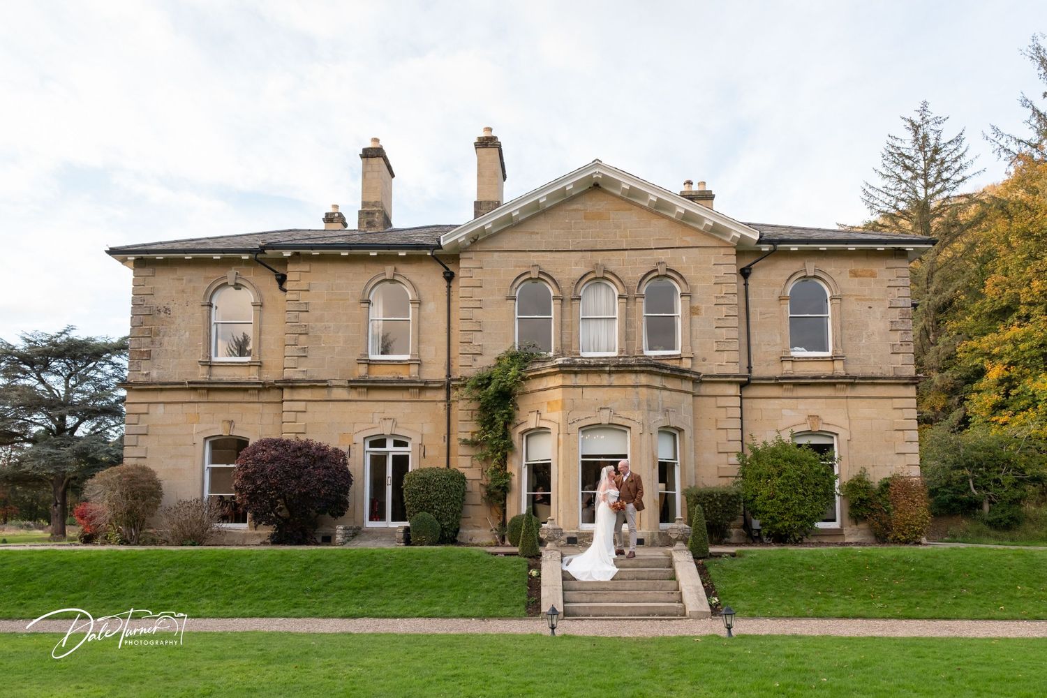 Elegant stone mansion wedding venue with manicured lawn and classic architecture.