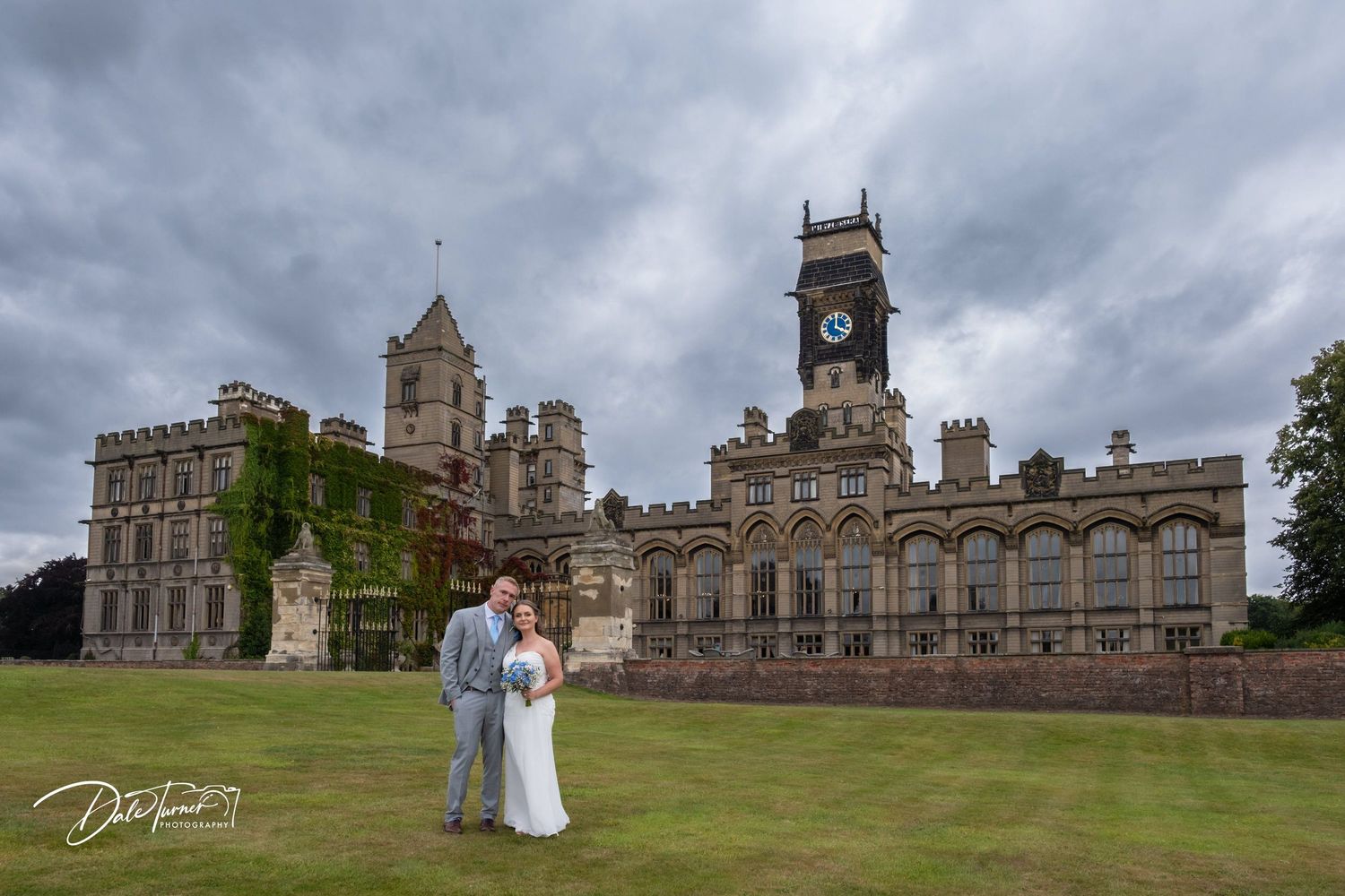Historic castle architecture creates stunning panoramic backdrop for wedding photos.