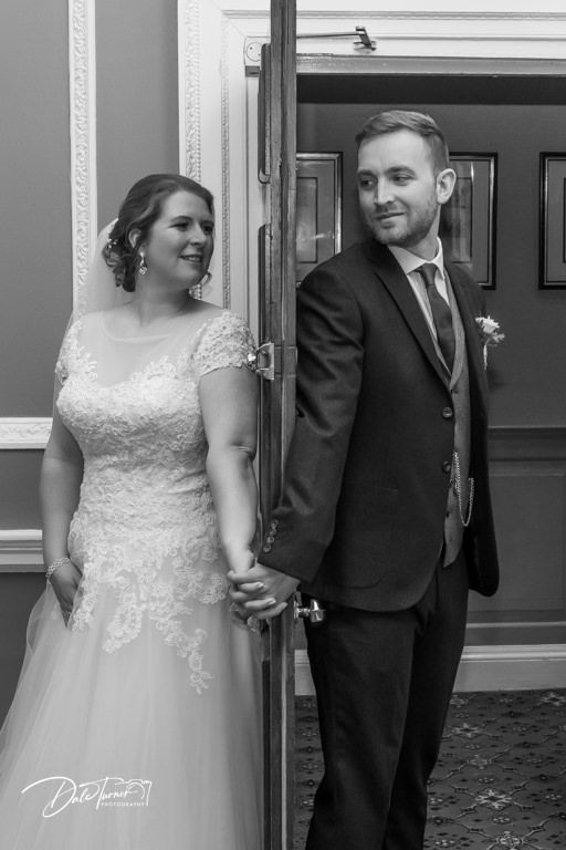 An intimate wedding portrait captured in an elegant interior hallway with classic moldings.