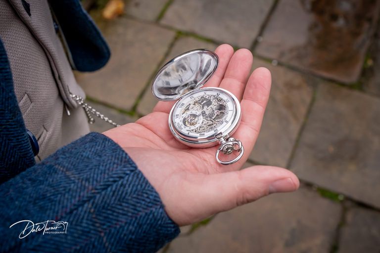 Close-up of commemorative wedding coins being displayed in open hands.