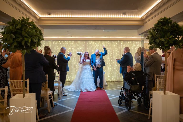 Elegant indoor wedding venue with cove lighting and decorative ceiling details.