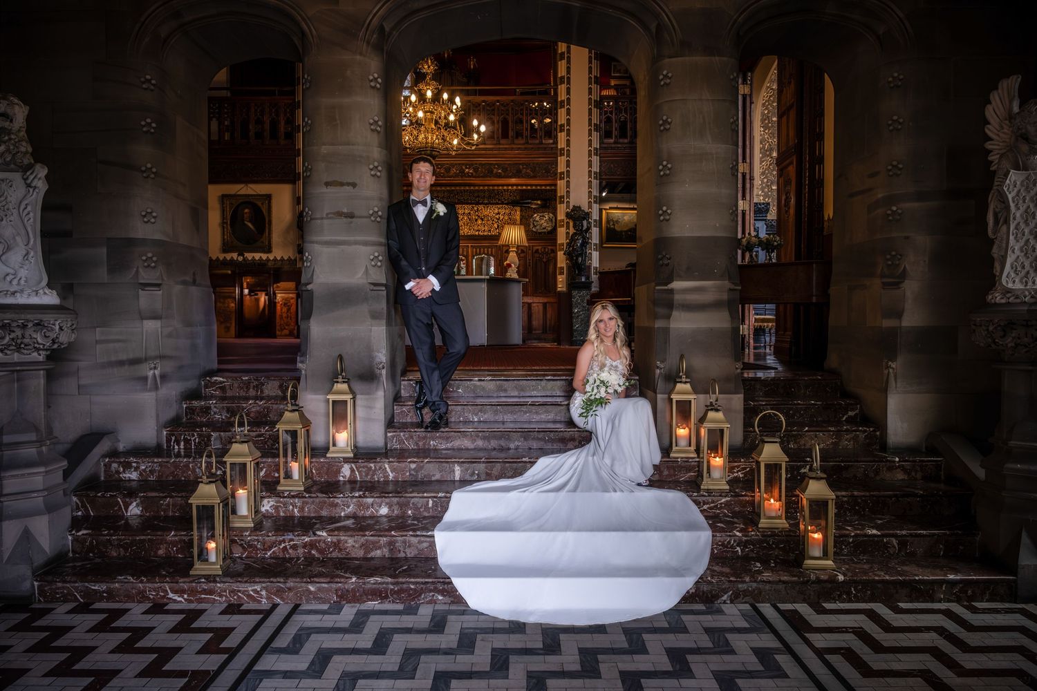 A romantic evening portrait on stone steps decorated with glowing lanterns.