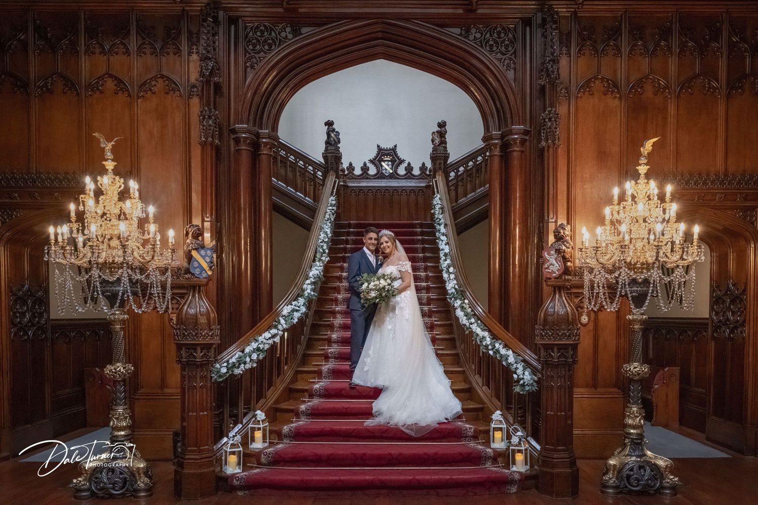 Gothic-style wedding venue with red carpet aisle and crystal chandeliers.