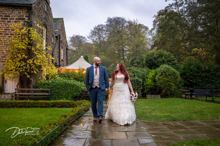 Wedding photography at historic stone venue with autumn foliage and garden scenery.