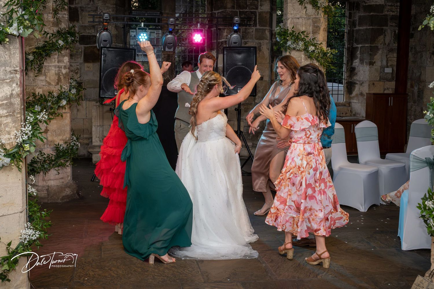 Wedding party dancing and celebrating on the dance floor at a reception.
