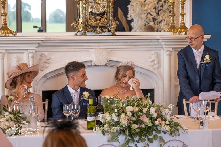 Wedding reception dining room with luxurious decorations and formal table settings.