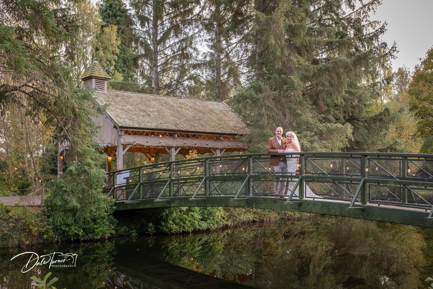 Panoramic view of wooden bridge walkway surrounded by autumn trees.