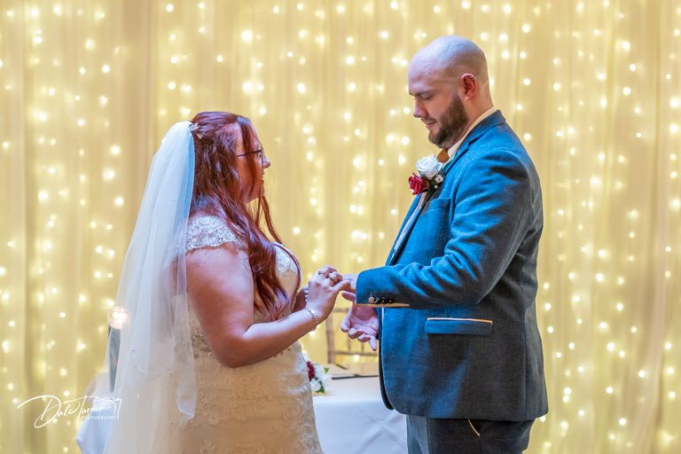A romantic wedding moment captured against a glowing backdrop of string lights.