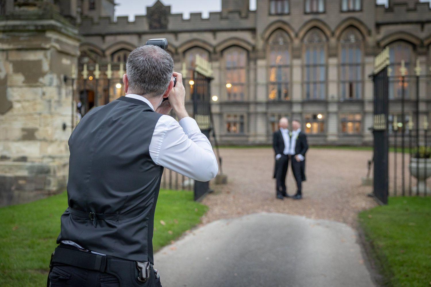 Gothic stone castle courtyard and steps create an elegant wedding venue backdrop at dusk.