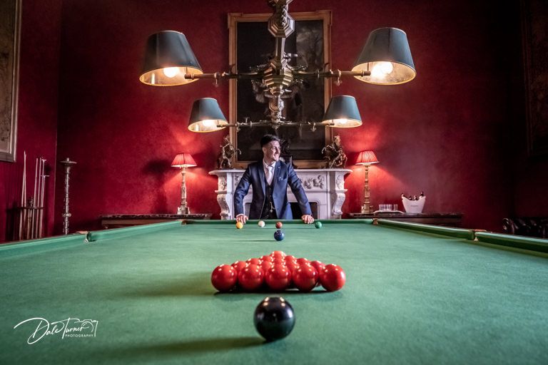 Snooker table with red balls arranged in a triangle on green felt.