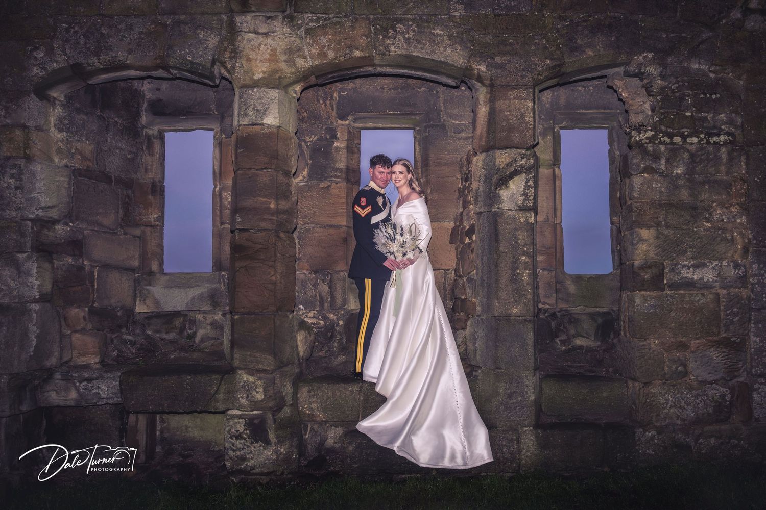 Wedding photos captured against historic stone walls and archways at dusk.