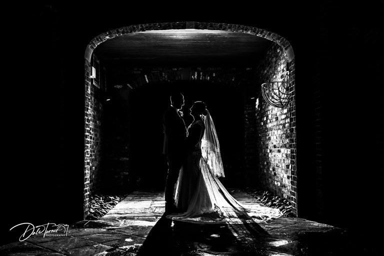 Artistic silhouette wedding photos captured in dramatic lighting.