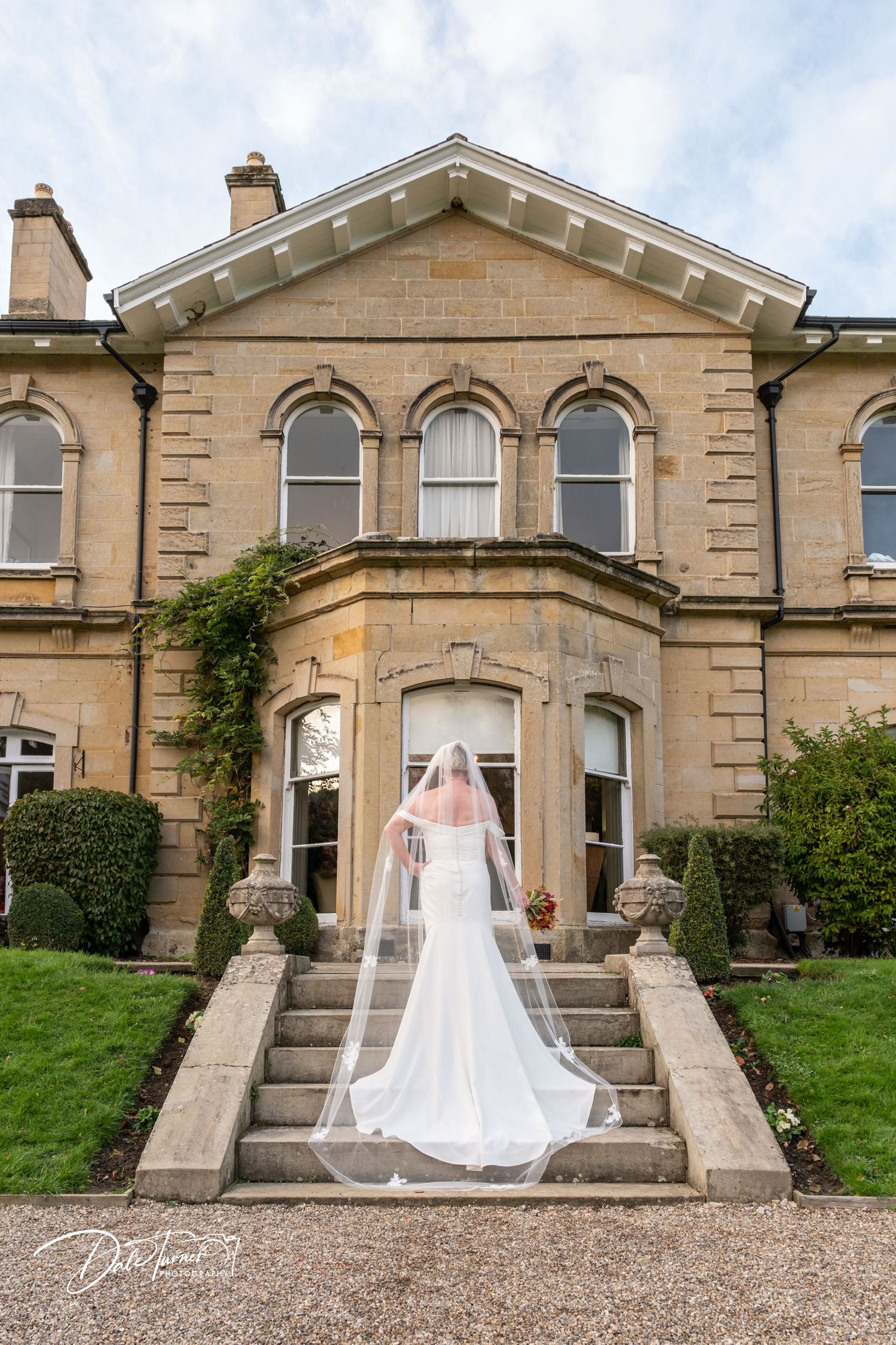 Stately stone manor house with symmetrical architecture and grand entrance steps.