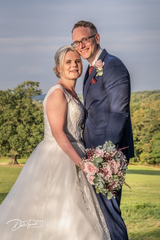 Happy couple shares intimate moment in garden setting during sunset.