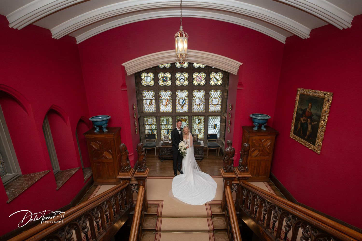 Elegant red-walled room with ornate architectural details and white ceiling beams in a historic venue.