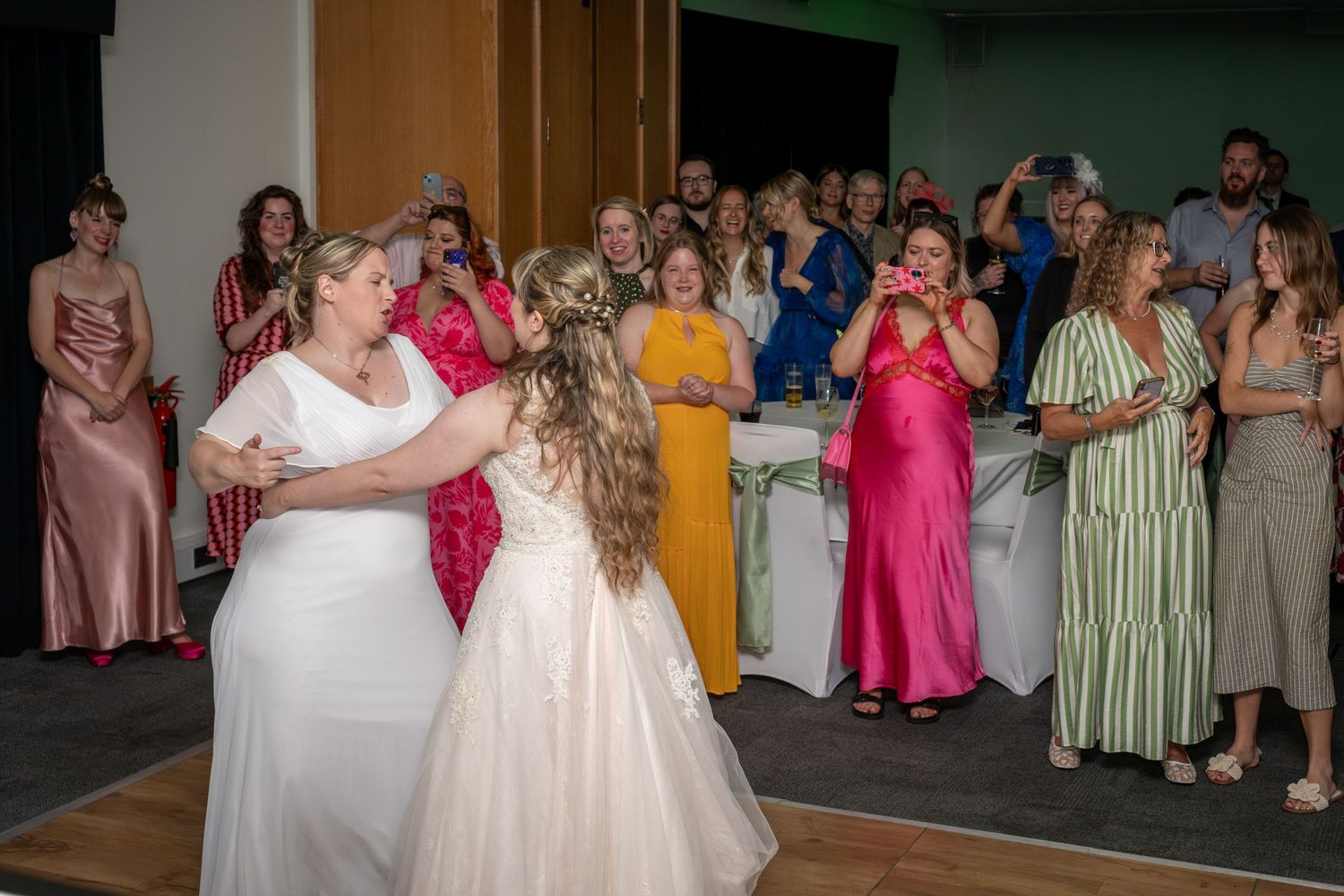 Wedding reception dance floor scene with guests in colorful dresses enjoying the celebration.