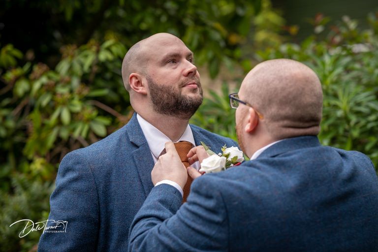 Wedding party members share emotional moment outdoors during celebration.