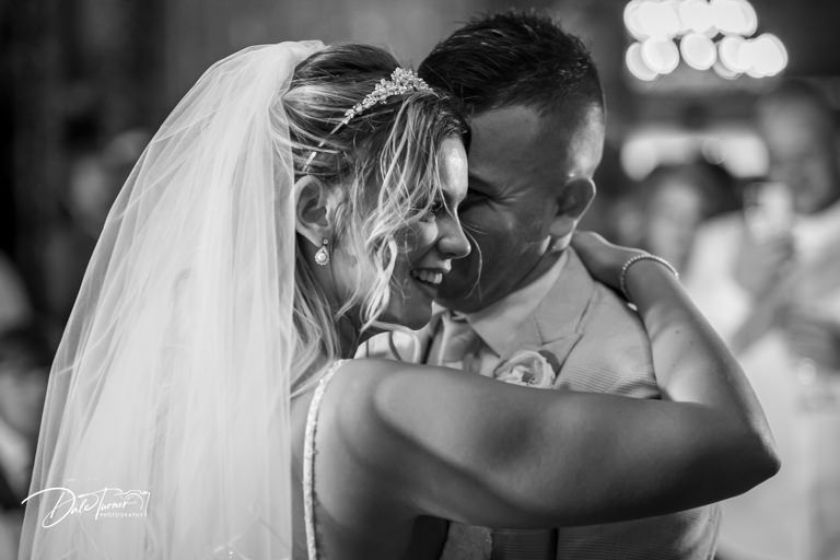 Intimate black and white dance moment captured during wedding reception.