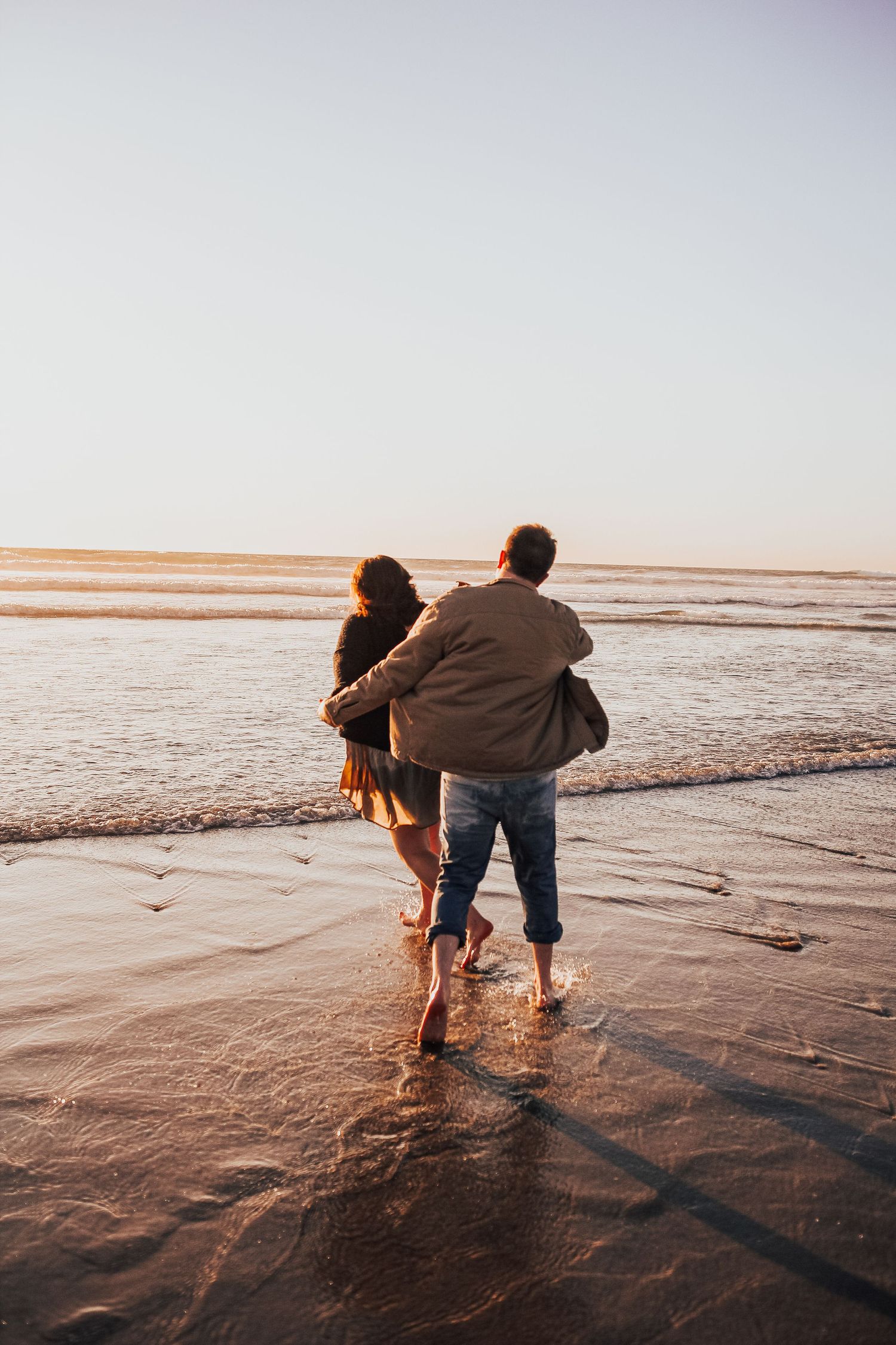 man and woman runs on beach in Encinitas, California