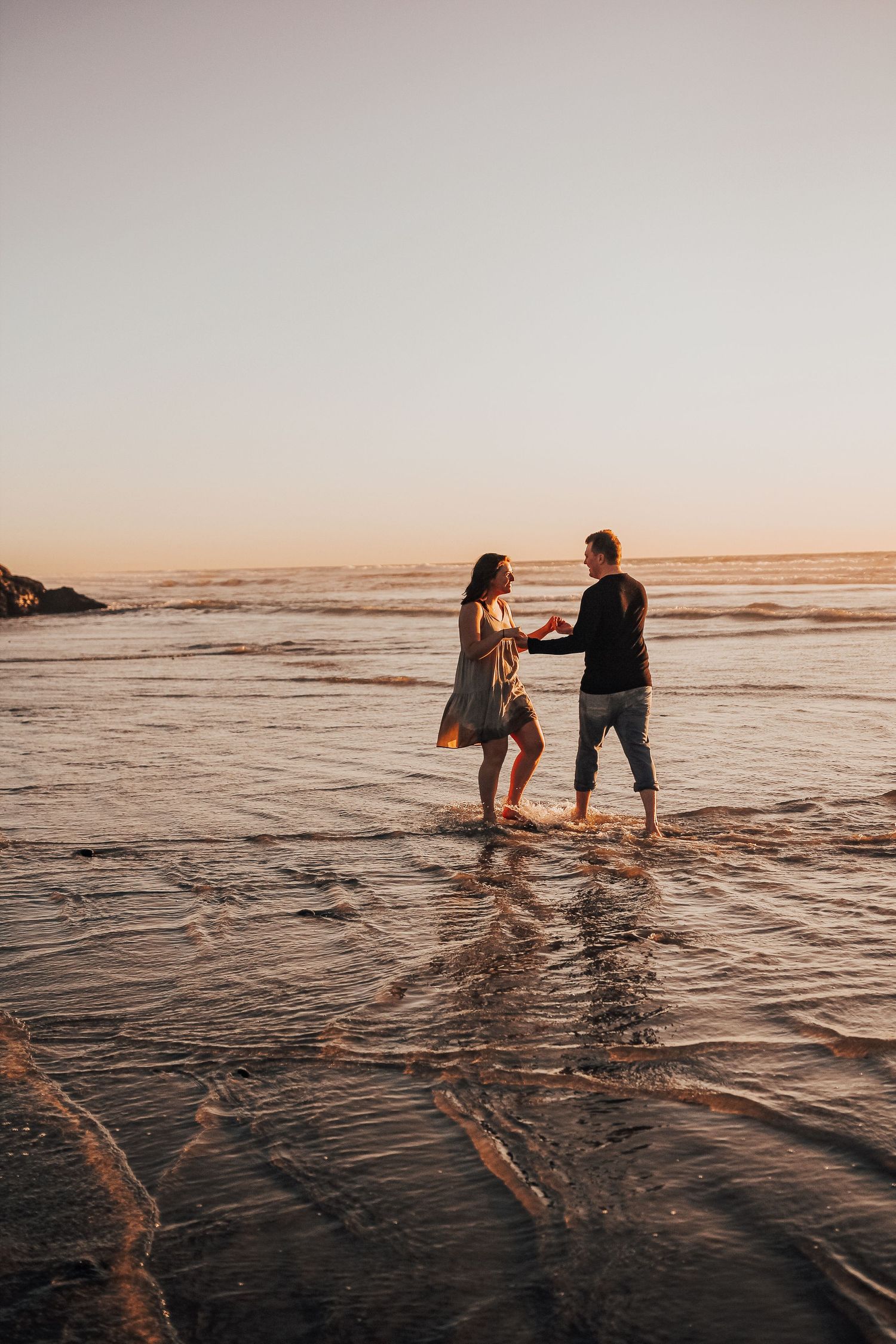 man and woman walk in ocean in Encinitas, California