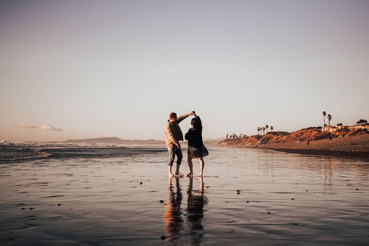 man and woman dances on beach in Encinitas, California