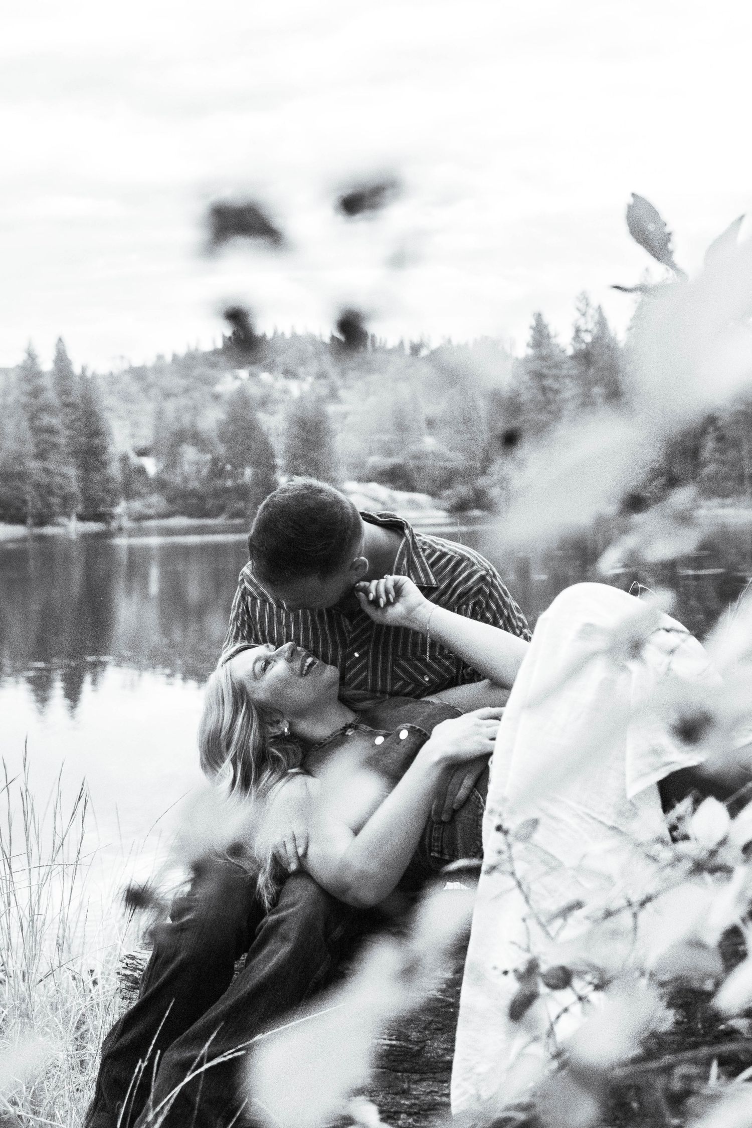 man and woman sit together by lake in Pine Grove, California