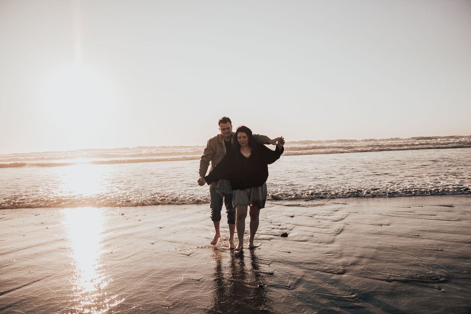 couple running together on beach in Encinitas, California