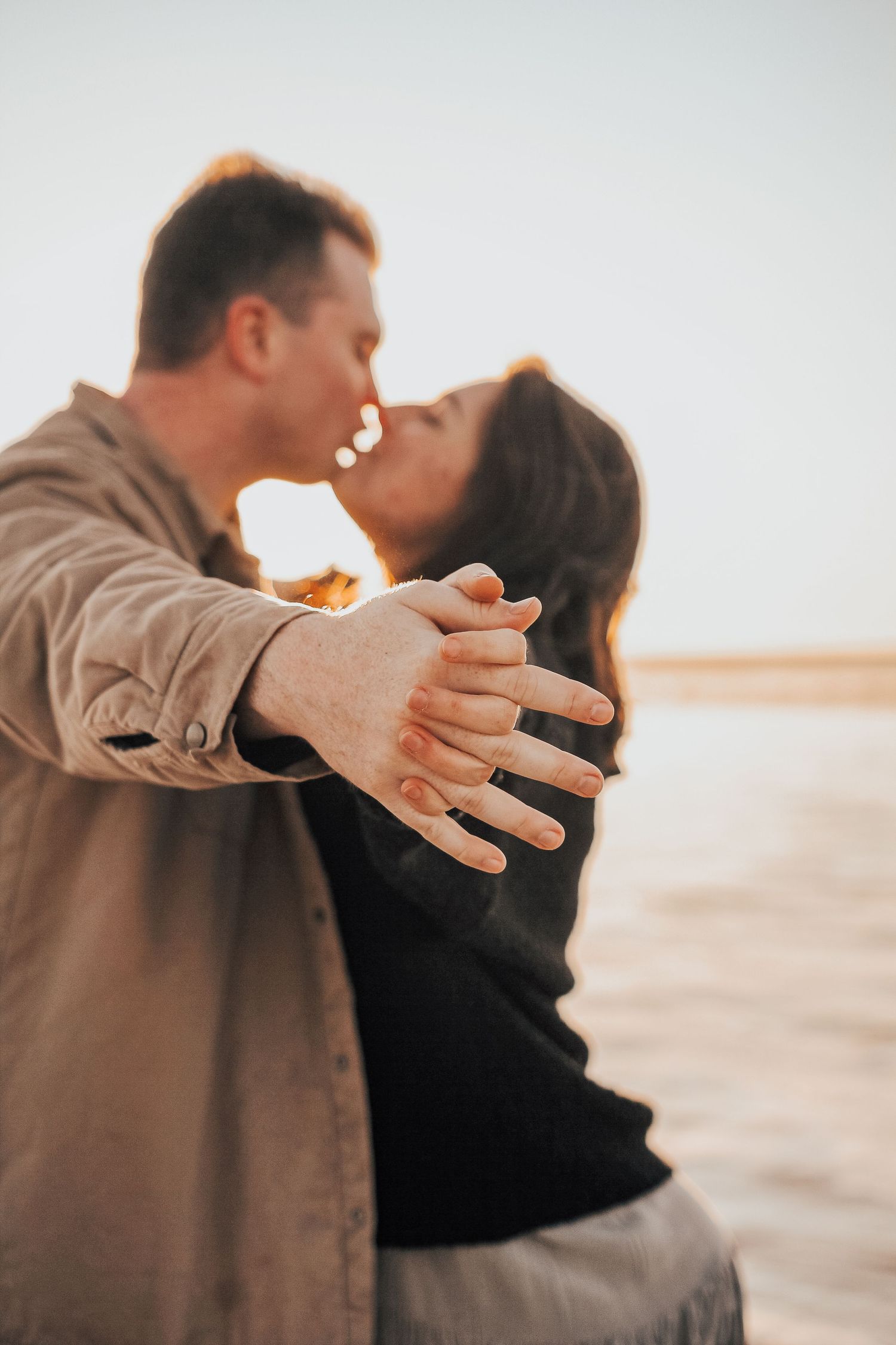 man and woman hold hands by rocks in Encinitas, California