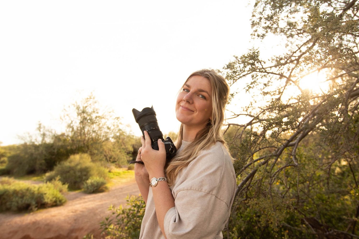 woman holding camera in desert
